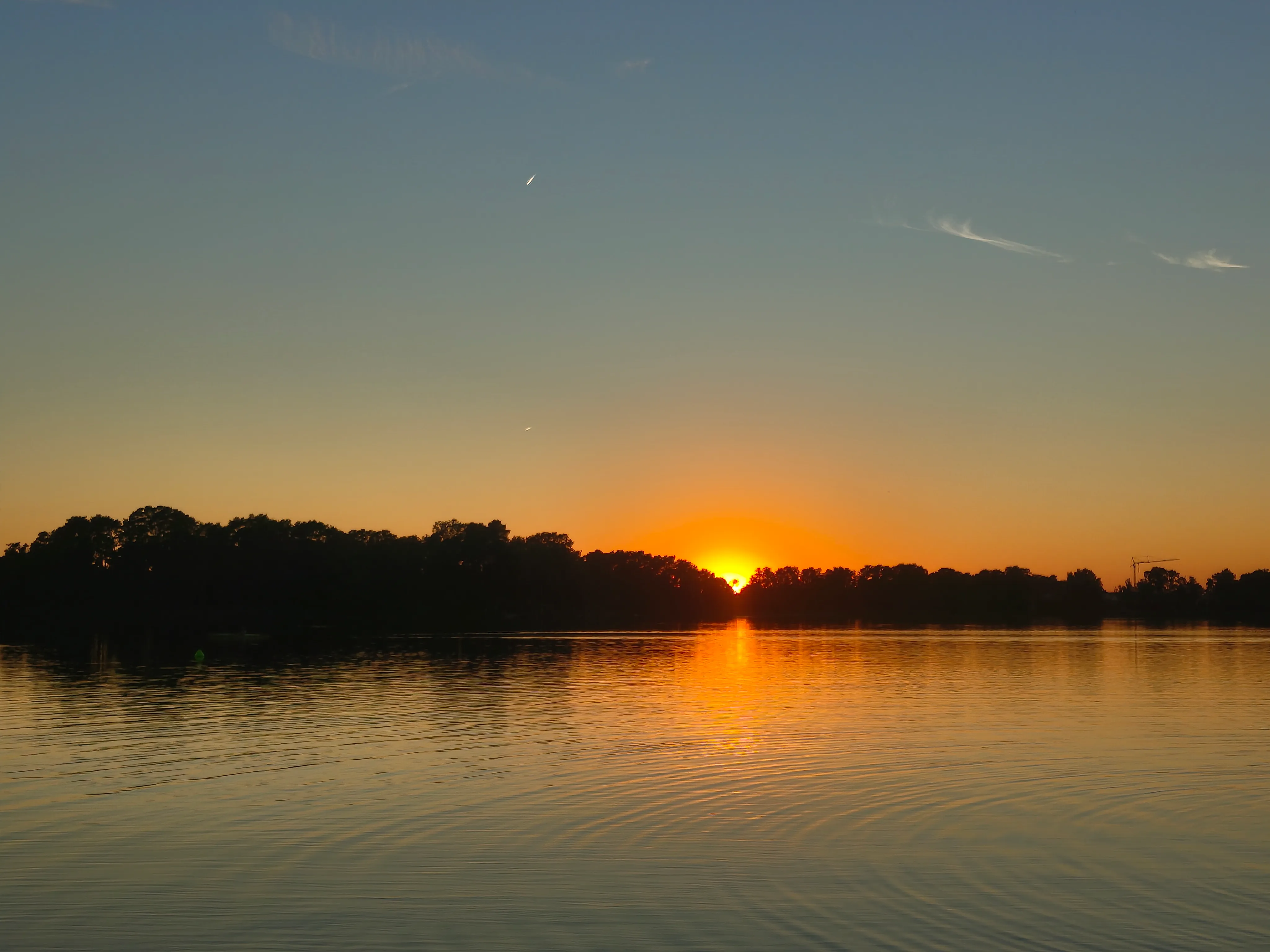 The eclipsing sun setting above a lake